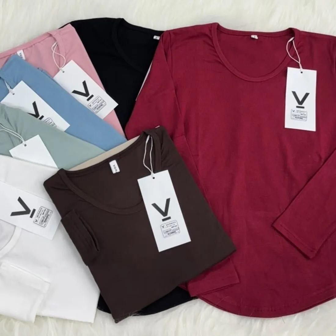 Long-sleeve knit t-shirts in multiple colours, laid flat